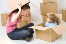 A woman playing with a child with boxes.